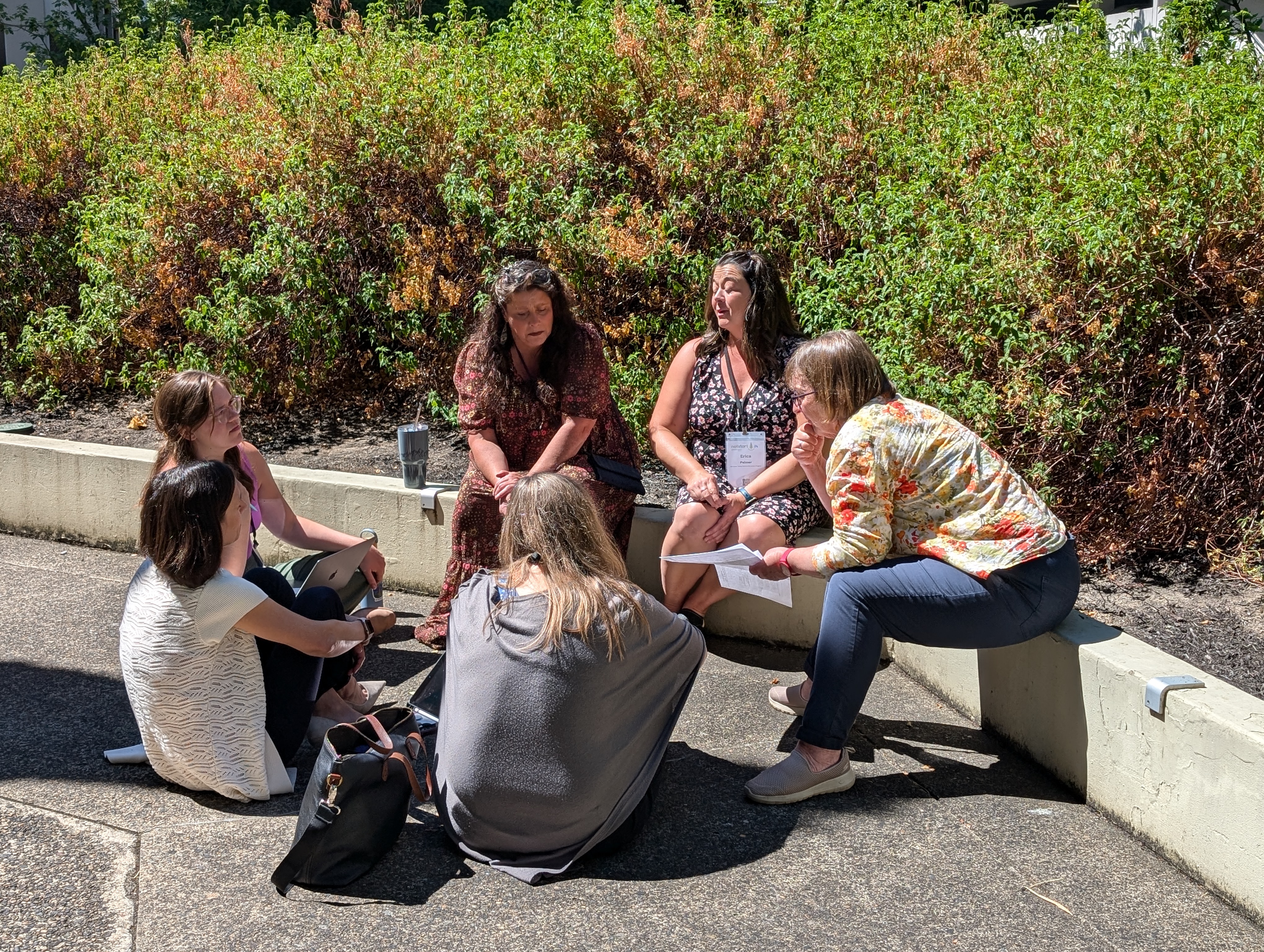 group of adults sitting outside talking