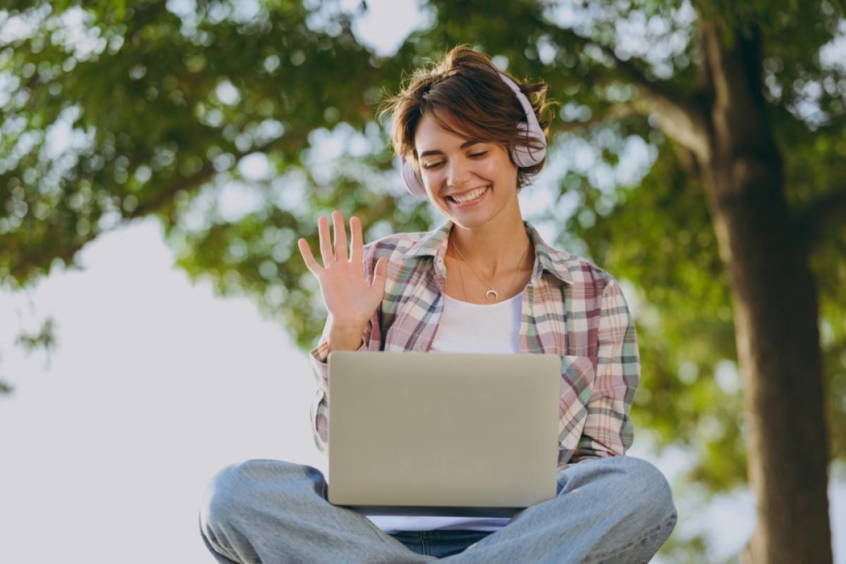 girl waving at laptop