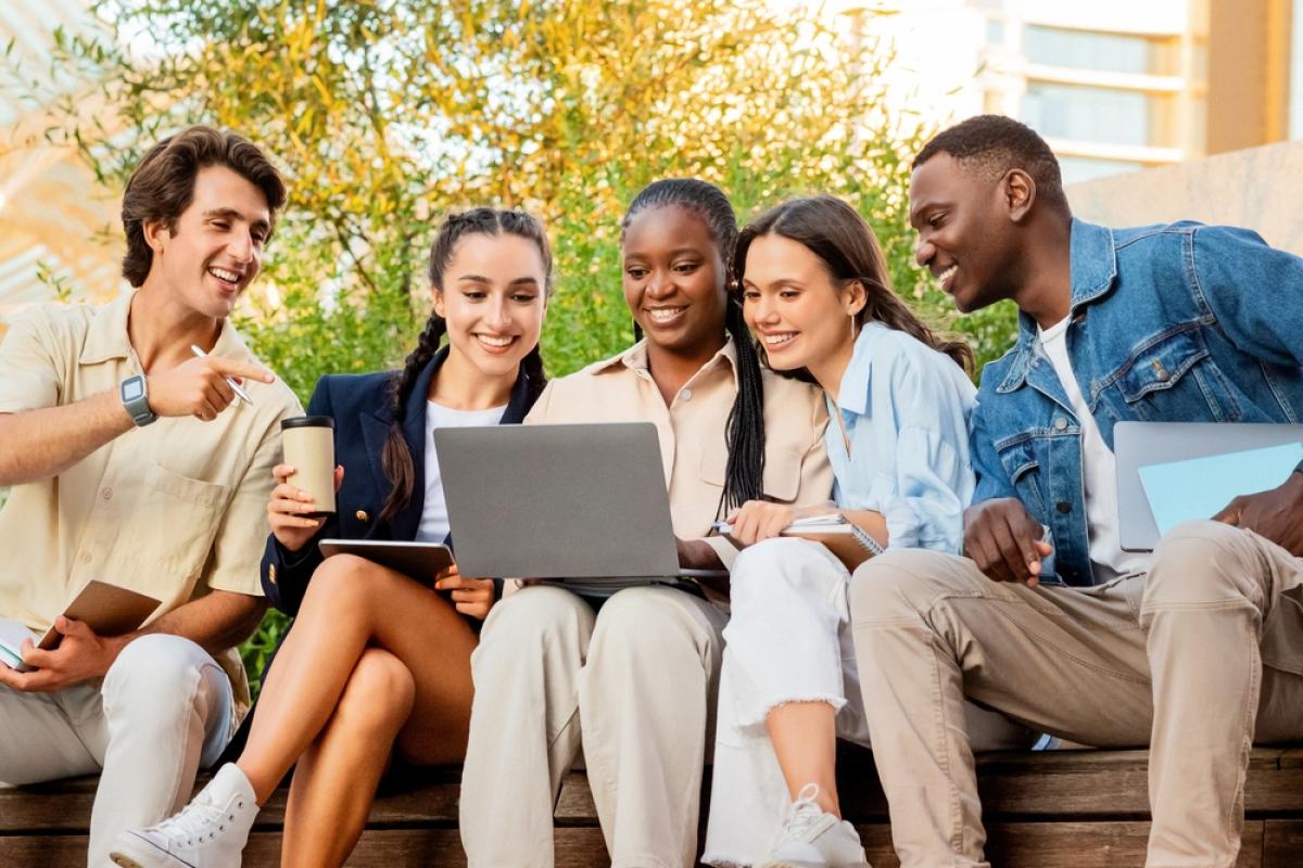 diverse student group looking at laptop