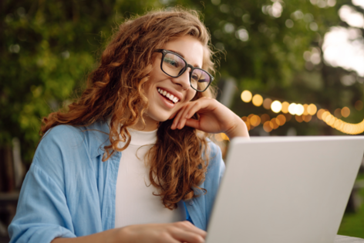 young happy woman on laptop outside